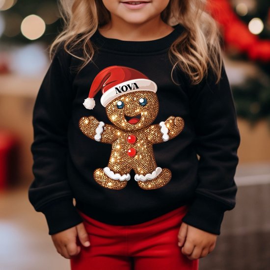 Sweatshirt noir avec un imprimé biscuit de Noël scintillant portant un bonnet de Noël et le nom 'NOVA'.