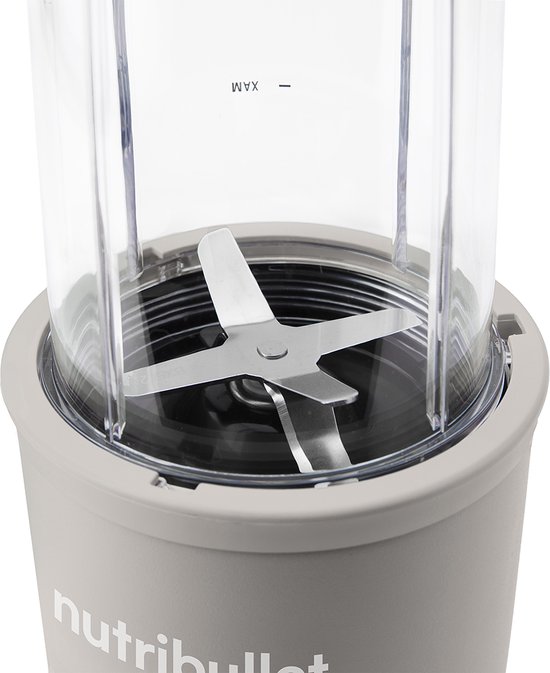 Detail van de zilverkleurige mesjes in de transparante beker van een linnen beige Nutribullet.