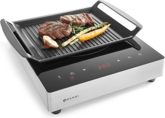 Inductie grillplaat met digitale display, waarop twee steaks, asperges, wortel en knoflook gegrild worden.