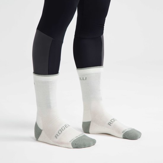 Een model draagt twee crème Rogelli fietssokken met grijze accenten.