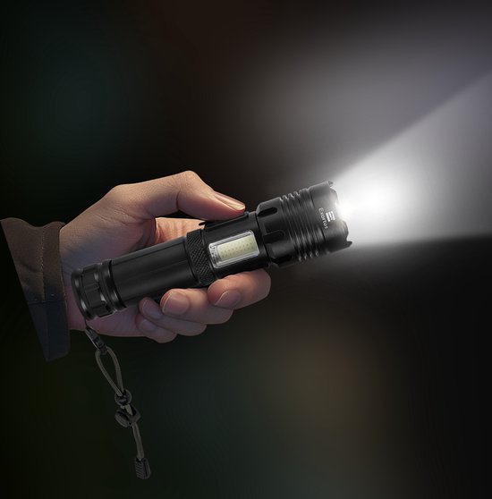 Een hand houdt een zwarte, waterdichte LED-zaklamp vast met een heldere lichtbundel.