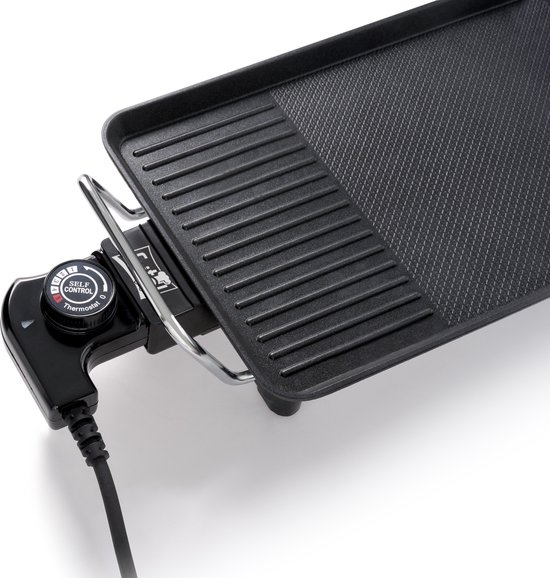 Detail van de zwarte elektrische grillplaat met thermostaatknop met 'Self Control' en 'Thermostatic'.