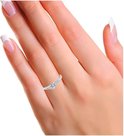 Zilverkleurige ring met één grote en twee kleine zirkonia's, gedragen door een vrouw met nette nagels.
