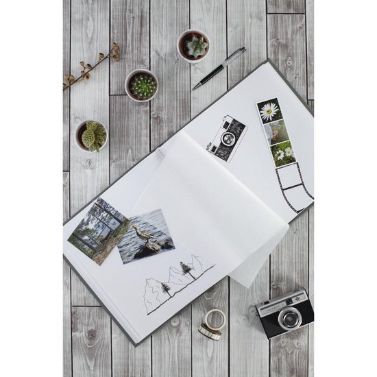 Open grijs album op een houten achtergrond met plantjes, een pen en een camera.
