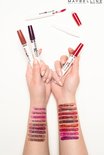 Verschillende Maybelline SuperStay 24 Color lipsticks op armen geswatched: rood, roze, nude en paars.