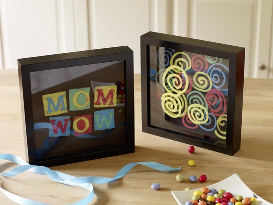 Twee zwarte lijsten met gekleurde letters 'MOM WOW' en cirkelpatronen, met blauwe linten.