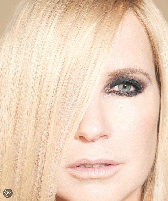 Vrouw met lang blond haar, waarvan een deel over haar gezicht valt. Zwart-wit.