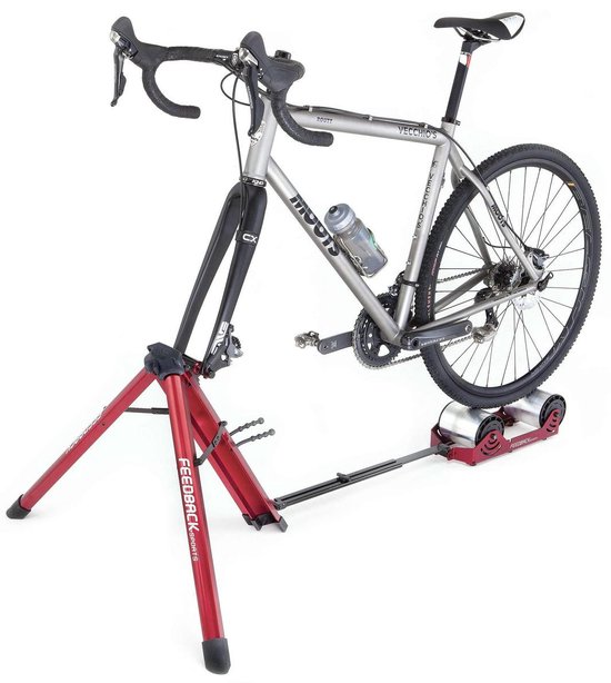 Racefiets op de rode Feedback Sports Omnium fietstrainer met rode standaard.