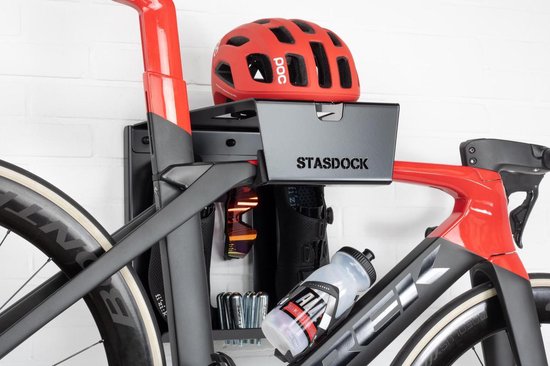 Close-up van de Stasdock fietsbeugel met een rode helm en bidon.