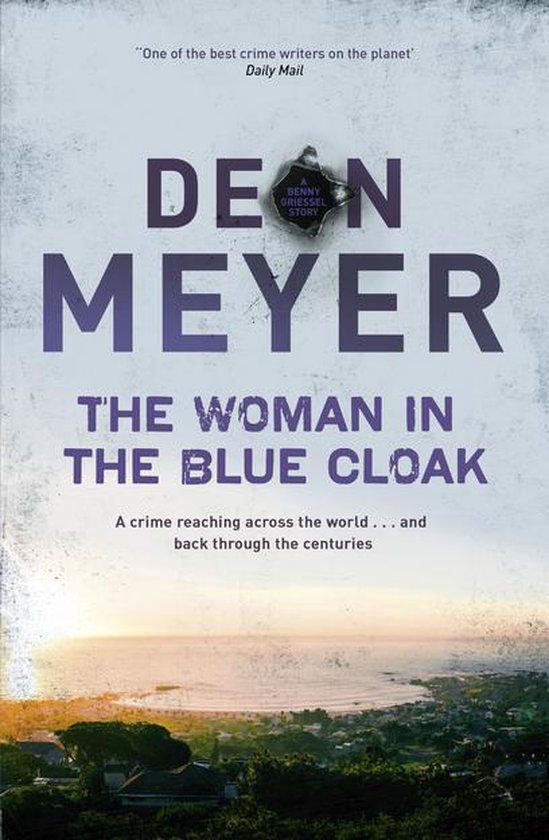 Boekcover 'The Woman in the Blue Cloak' door Deon Meyer, met een kogelgat en een foto van een kustplaats bij zonsondergang.