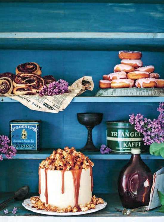 Gedecoreerde blauwe kast met gebak, donuts, koffieblikjes en bloemen.
