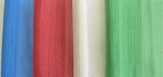 Blauw, rood, wit en groene antislipmatten met een fijn geruit patroon, naast elkaar getoond.
