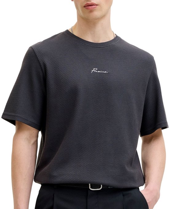 Man draagt een antracietkleurige T-shirt met hexagon patroon en 'Premium' logo, close-up borst.