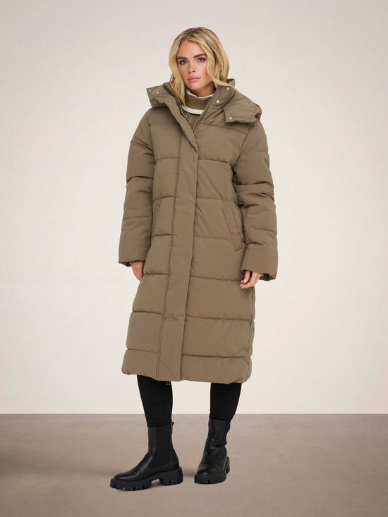 Model draagt bruine lange pufferjas met capuchon.