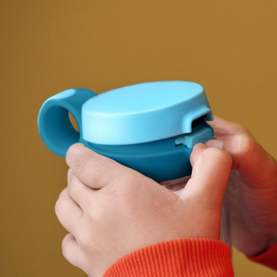 Kind opent de lichtblauwe en blauwe Mepal drinkfles dop met handvat.