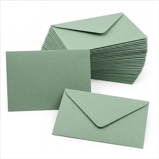 Une pile d'enveloppes vertes à côté d'une enveloppe simple et d'une feuille de papier carrée verte.