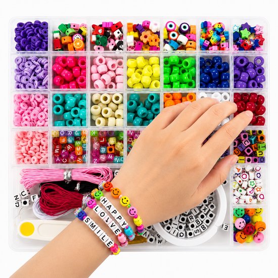 Grote kunststof bak met vakjes, gevuld met gekleurde kralen en letterkralen. Een hand maakt een kralenarmband met de tekst "HAPPY LOVE SMILE".