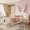 Beige kinderbed met konijnenoren, met opbergruimte en een nachtkastje, in een kinderkamer met roze muren.
