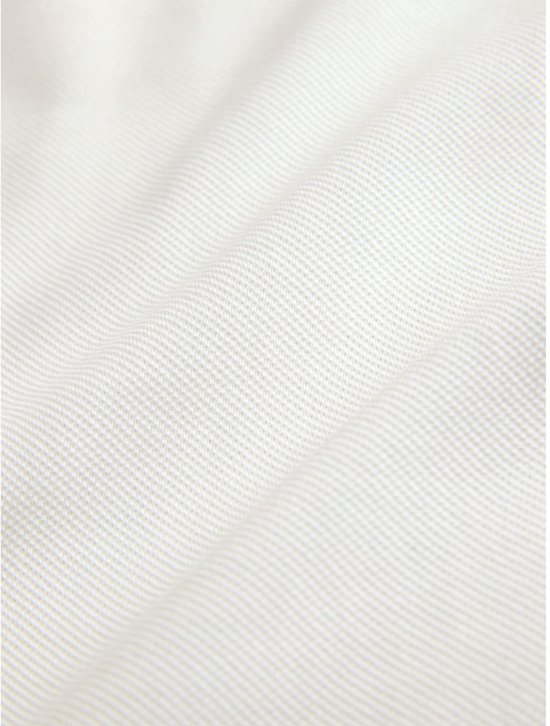 Detail van de stof van het crème poloshirt met een fijne ribbelstructuur.