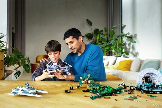 Vader en zoon kijken met plezier naar een LEGO Star Wars TIE Interceptor die ze aan het bouwen zijn.