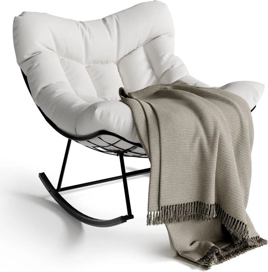 Witte schommelstoel met zwart frame, met een beige plaid met franjes eroverheen gedrapeerd.