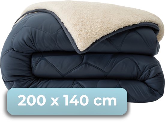 Donkerblauw dekbed, gevouwen, met een crème teddy voering. Afmeting 200 x 140 cm.