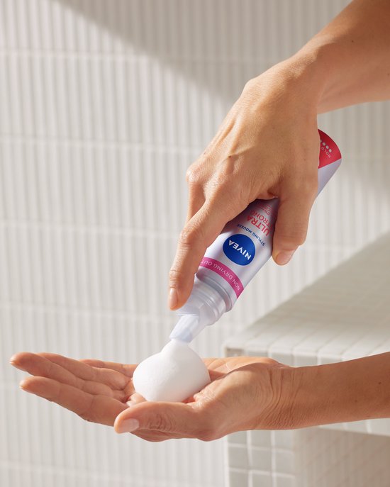 Handen houden NIVEA Ultra Strong styling mousse fles, spuit schuim in handpalm.
