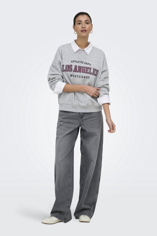 Model draagt grijze sweater met "ATHLETIC DEPT. LOS ANGELES WESTCOAST" print en wijde jeans.