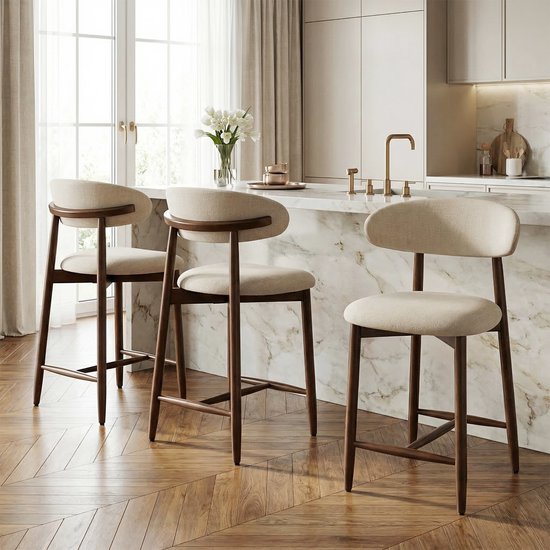 Drie beige barkrukken met houten poten en rugleuning bij een keukenbar.