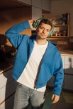 Man met groene koptelefoon en een blauw vest.