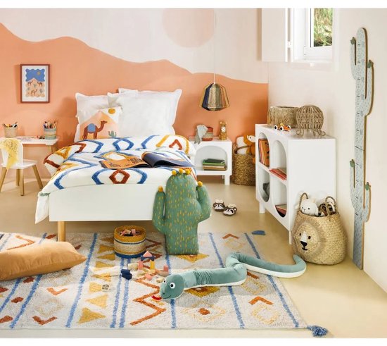 Kinderkamer met bed, speelgoed en een tafel met stoelen.