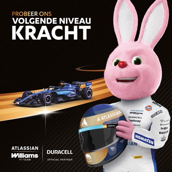 Le lapin rose Duracell tient un casque de Formule 1, avec une voiture de F1 Williams en arrière-plan.