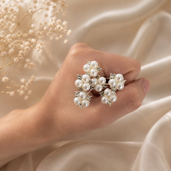 Barrette argentée avec motif floral de perles et strass, sur une main.