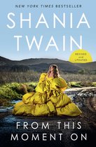 Boek 'From This Moment On' van Shania Twain met op de cover een vrouw in een gele jurk in een landschap.