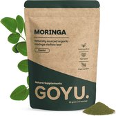 Bruine zak met "MORINGA Naturally sourced organic moringa oleifera leaf" en "GOYU." erop, met links een takje moringabladeren en rechts een hoopje poeder.