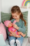 Kindje voedt BABY born Emma pop met flesje. Pop draagt roze outfit en muts met oortjes.