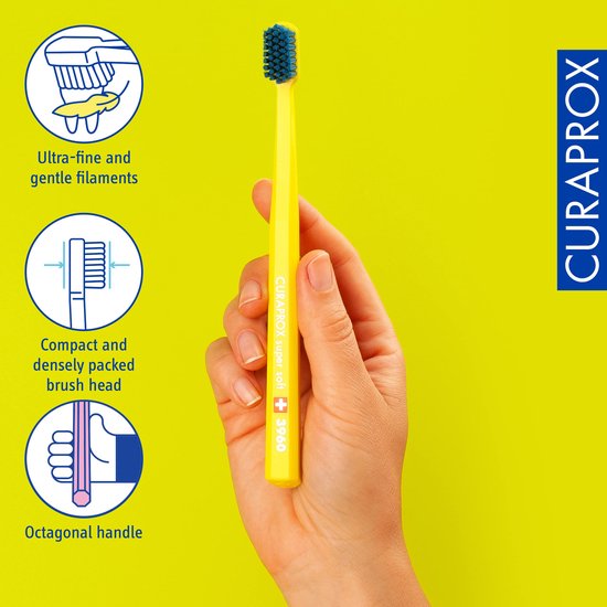 Gele Curaprox tandenborstel met blauwe borstelkop. Ultra-fijne filamenten, compacte kop, achthoekig handvat.