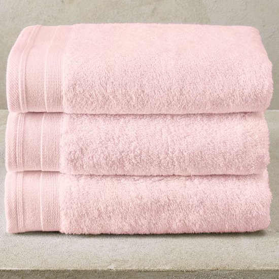 Trois serviettes de bain roses empilées avec une bordure côtelée.