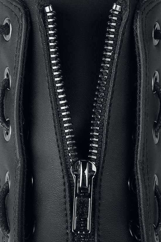 Close-up van de zilverkleurige ritssluiting op een zwarte sneaker.