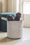 Deux chiots bruns dans un panier de rangement gris en velours côtelé avec "TOYS!" dessus.