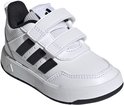 Witte peuterschoen met klittenbandsluiting, zwarte adidas strepen en witte zool, van voren gezien.