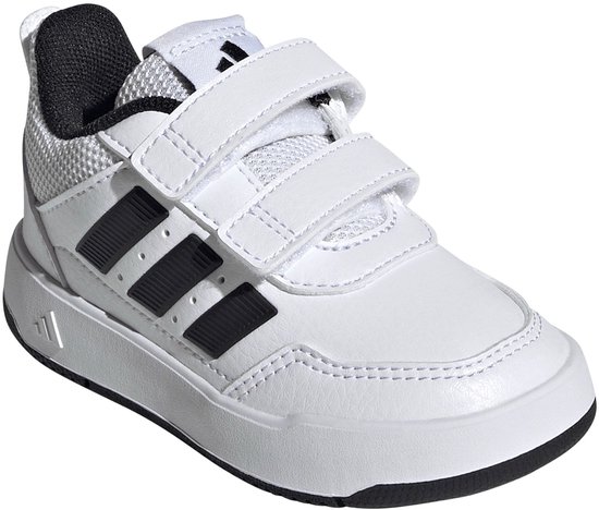 Witte peuterschoen met klittenbandsluiting, zwarte adidas strepen en witte zool, van voren gezien.