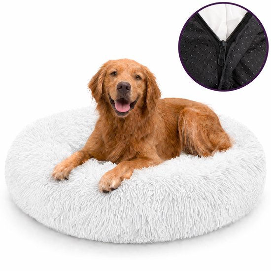 Un golden retriever joyeux est allongé dans un panier rond, blanc et duveteux avec un gros plan sur le dessous antidérapant.