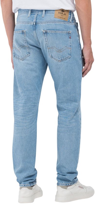 Arrière d'un jean Replay bleu clair à cinq poches et une étiquette en cuir marron.