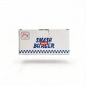 Witte kartonnen verpakking voor smash burger pers met 'SMASH BURGER PRESS' logo en blauw-wit geblokte rand.
