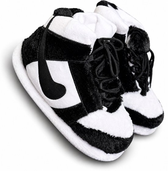 Zwart-witte pluizige pantoffels in sneaker-design, met veters en een zwart logo op de zijkant.