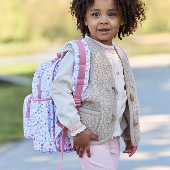 Fille portant un sac à dos avec imprimé floral et de fées, bretelles roses et poche avant.