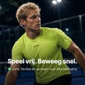 Atleet in een limegroen RAQA sportshirt op een padelbaan.