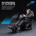 Man met headset, hoofdtelefoon en microfoon, zittend in een zwarte racekuipstoel, met de handen op een race stuur