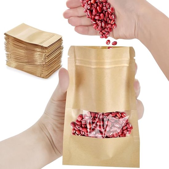 Hand die rode bonen in een bruin kraft papieren zakje met venster giet, naast een stapel zakjes.